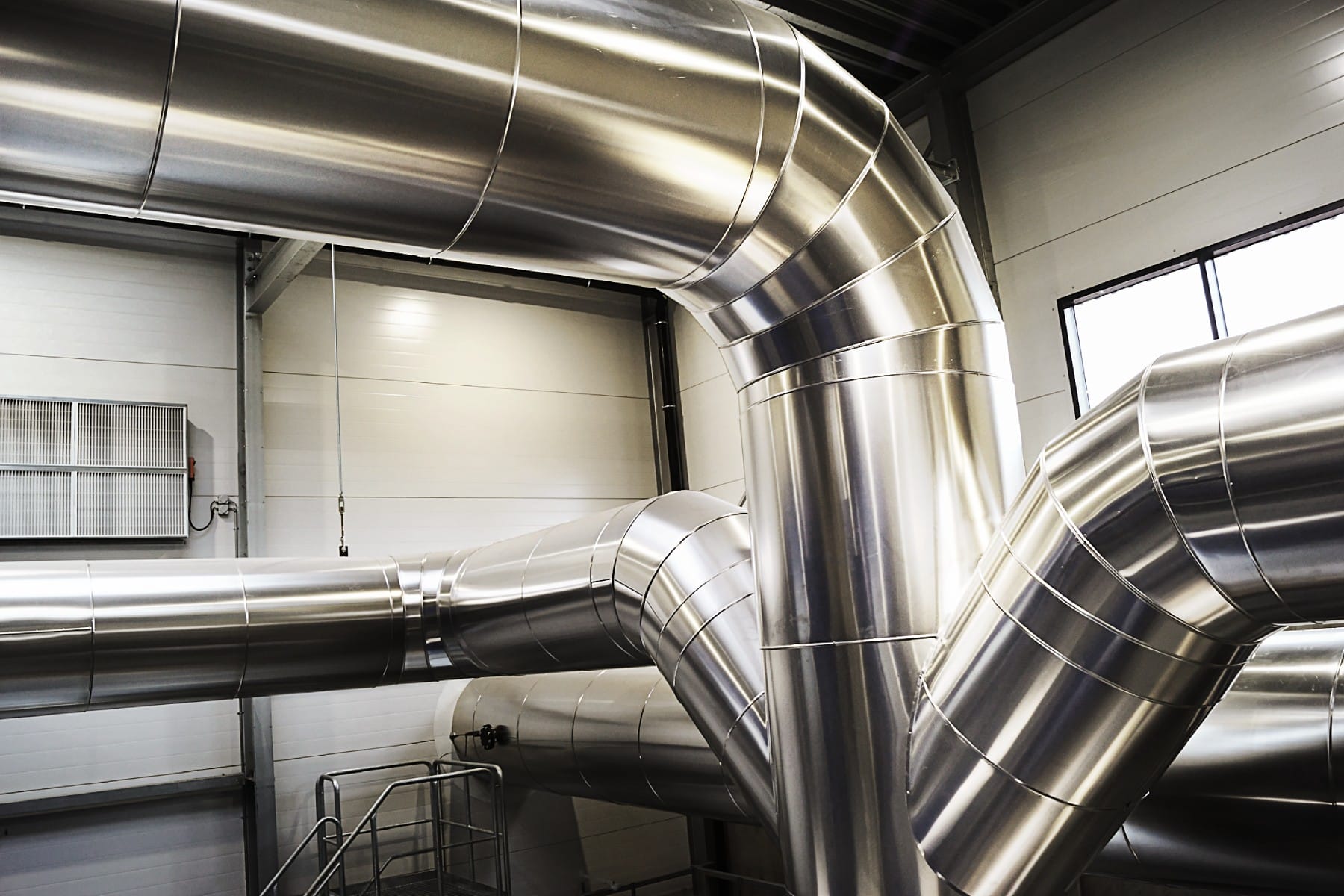 teknisk-isolering-roercaesium Professionel teknisk isolering af store industrirør med blank aluminiumskappe – præcisionsmonteret isoleringssystem til varme- og ventilationsanlæg i energifacilitet. Leveret af Altisol Industri Isolering.